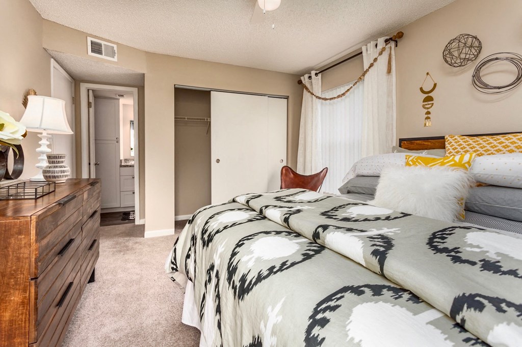 a bedroom with two beds and a dresser and a bathroom