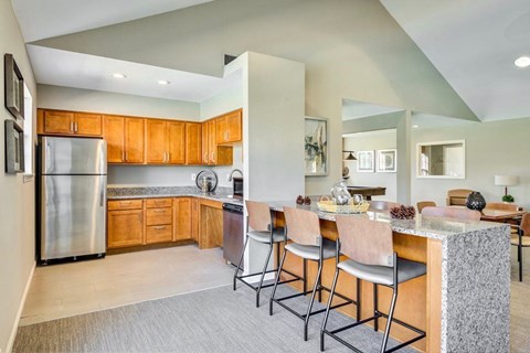 A kitchen with wooden cabinets and a stainless steel refrigerator.