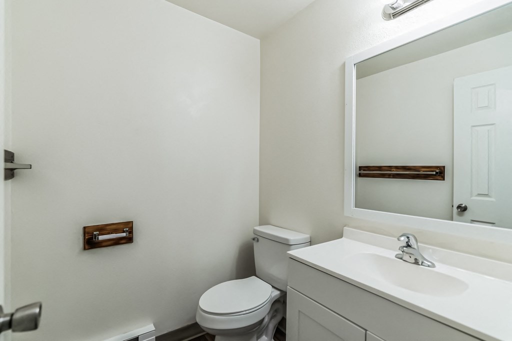 a bathroom with a sink toilet and a mirror