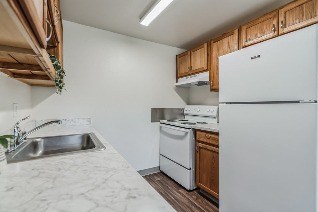 a kitchen with white appliances and wood cabinets