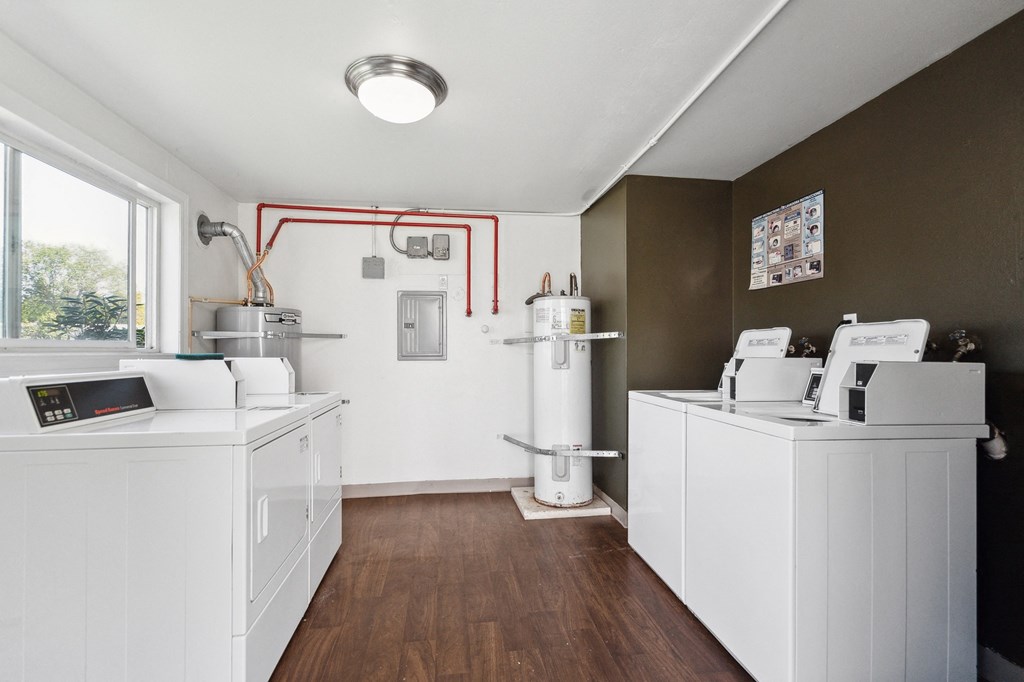a kitchen with two washers and dryers and a window