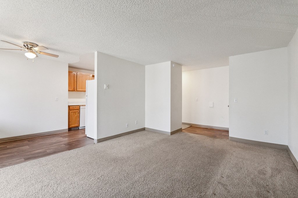 an empty living room with white walls and wood flooring