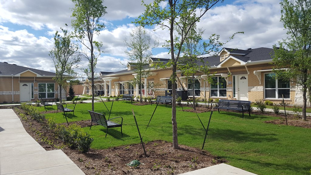a yard with benches and a building in the background