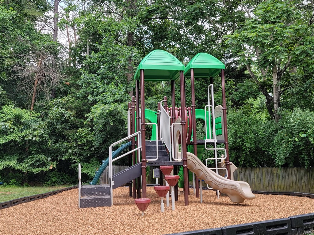 a playground with a set of slides in a park