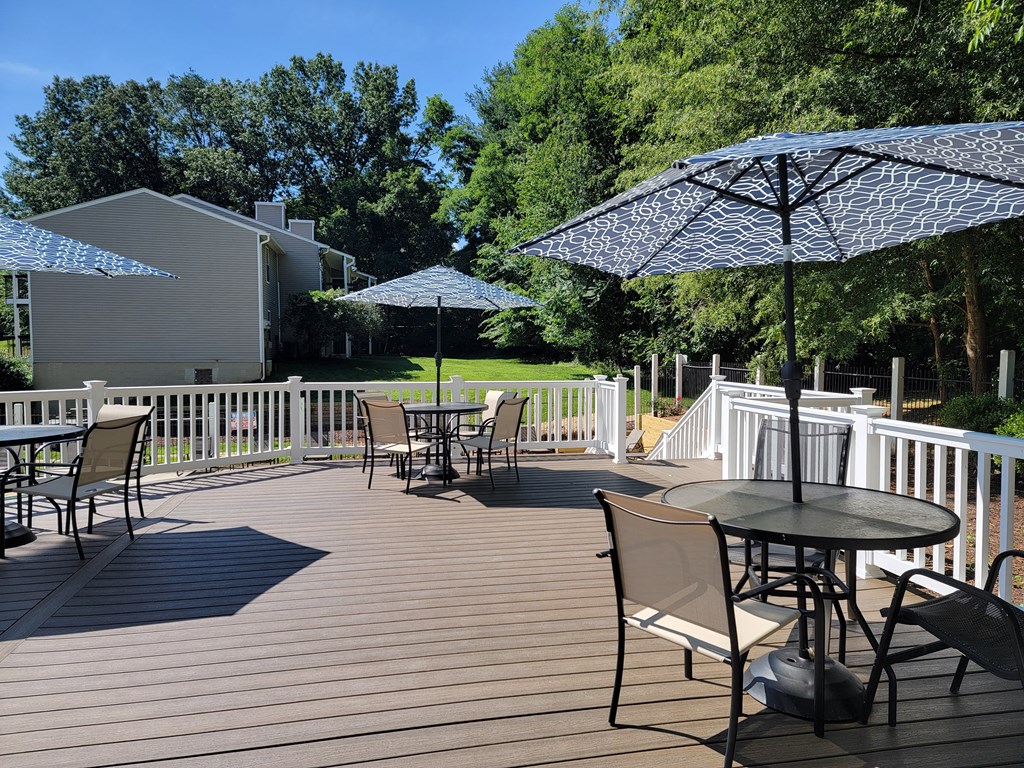 a patio with tables and umbrellas on a deck