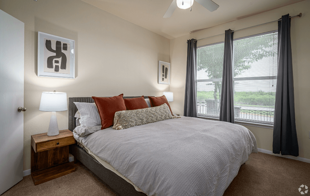 a bedroom with a bed and two windows