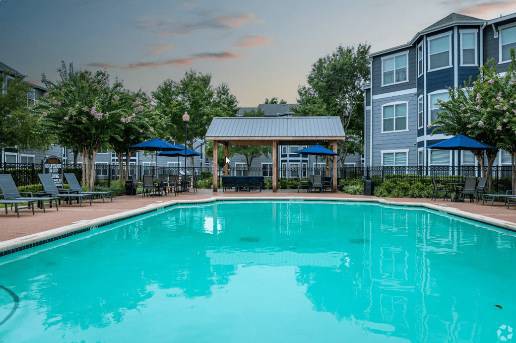 a swimming pool with a gazebo in front of a building
