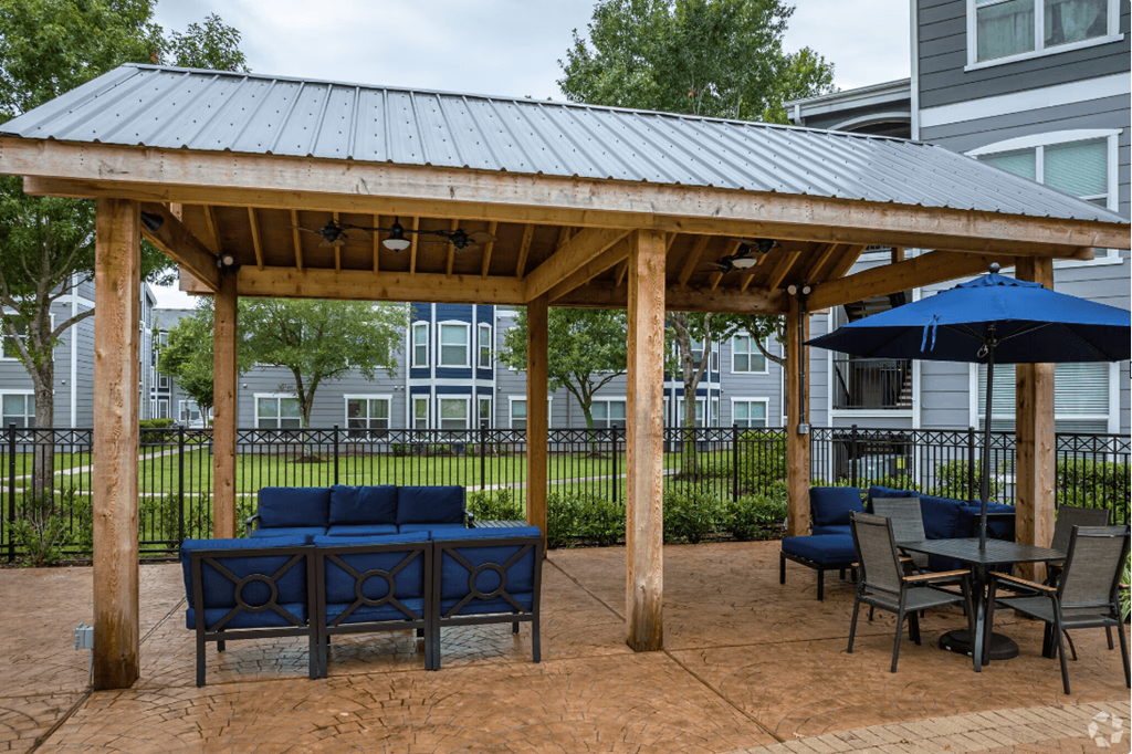 a pavilion with a seating area and tables with umbrellas