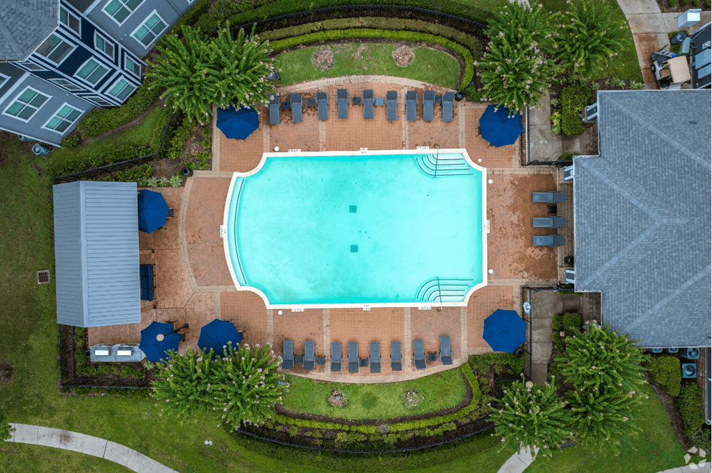 arial view of a swimming pool with umbrellas and trees