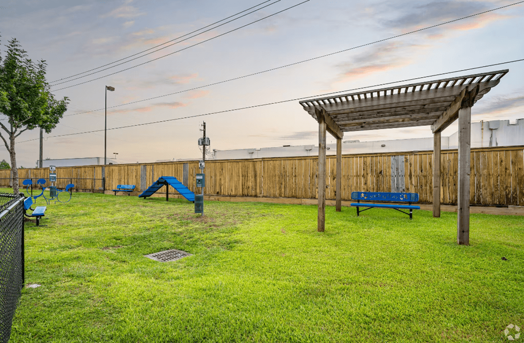 a playground with a swing set and a pergola