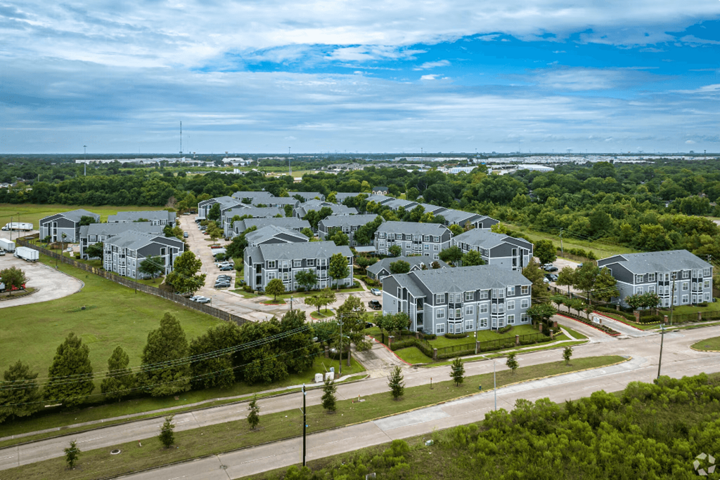 an aerial view of a large housing complex with green grass and trees