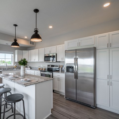A modern kitchen with white cabinets and a large island.