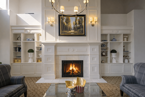 A living room with a fireplace and a painting on the wall.