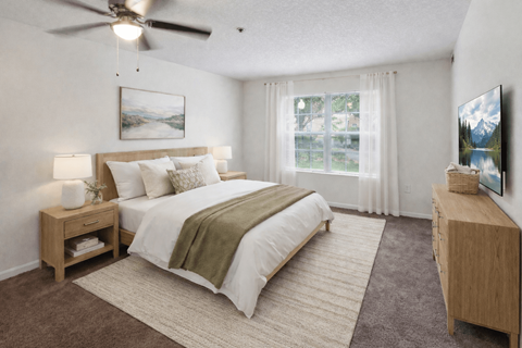 A bedroom with a large bed and a ceiling fan.