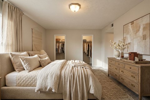 A bedroom with a large bed and a dresser.