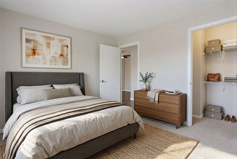 A bedroom with a large bed and a wooden cabinet.