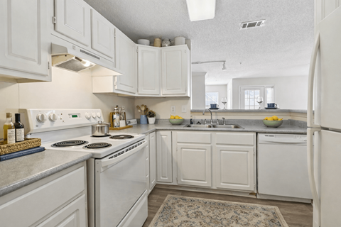 A kitchen with white cabinets and appliances.