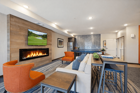 A modern living room with a fireplace and a television playing a golf game.