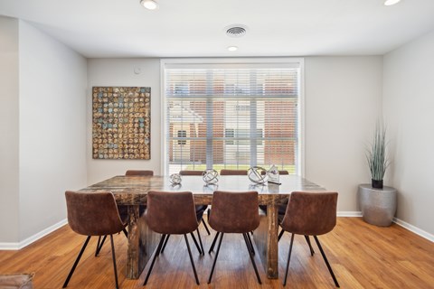 A dining room with a table and chairs.