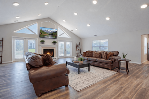 A cozy living room with a fireplace and a large couch. at Arbors at Hickory Creek Apartments , University Park, IL, 60484