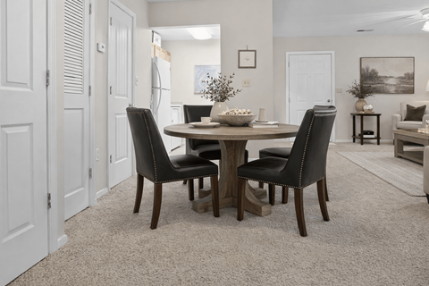 A dining room with a table and chairs.