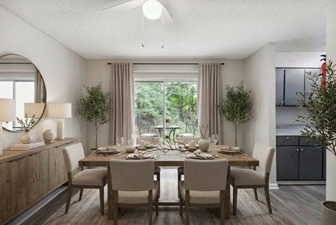 A dining room with a table set for four and a view of the backyard.
