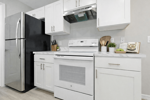 A modern kitchen with white appliances and cabinets.