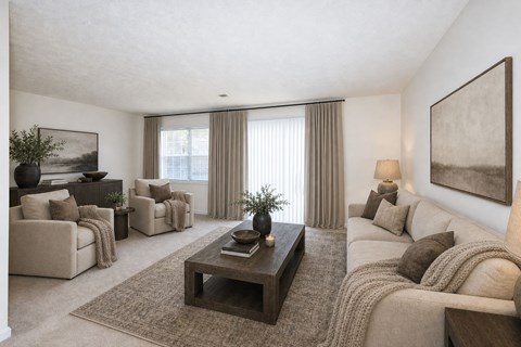 A living room with a large couch, a coffee table, and a painting on the wall.