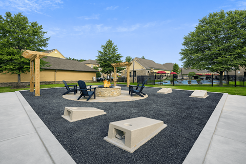 A playground with a black rubber surface and concrete structures.