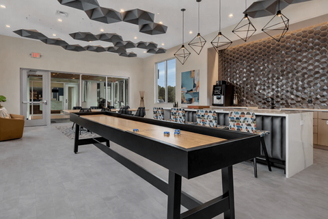 A modern kitchen with a long black table and a patterned backsplash.
