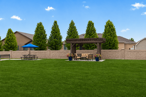 A backyard with a picnic table and a gazebo.