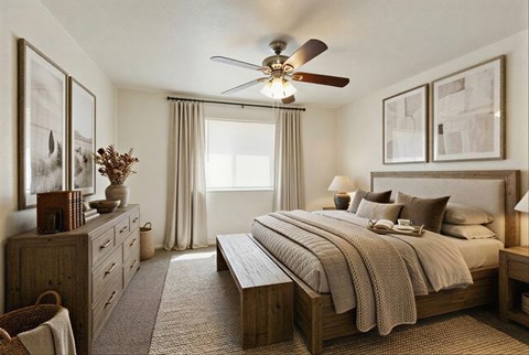 A bedroom with a large bed and a ceiling fan.