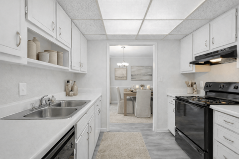 A kitchen with white cabinets and a black stove top oven.
