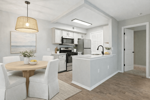 A modern kitchen with white chairs and a wooden table.