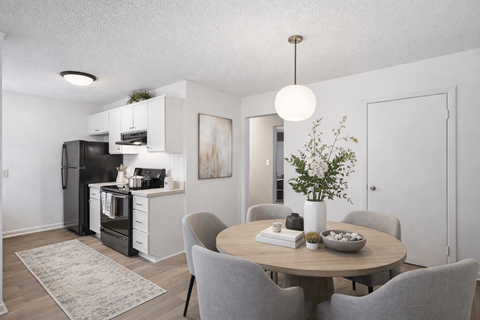 A modern kitchen with a dining table and grey chairs.