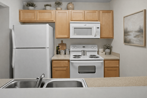 A kitchen with a white refrigerator, a white microwave, a white stove, and a white oven.