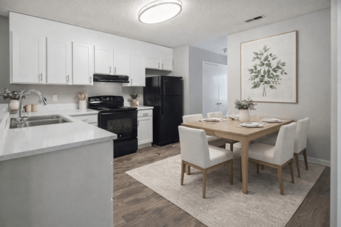 A kitchen with a dining table and chairs.