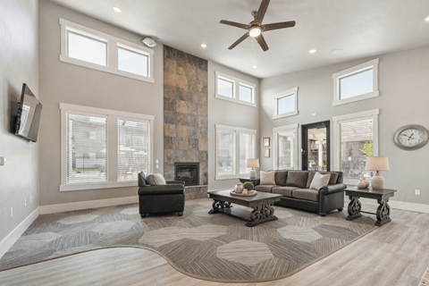 A living room with a fireplace and a rug on the floor.