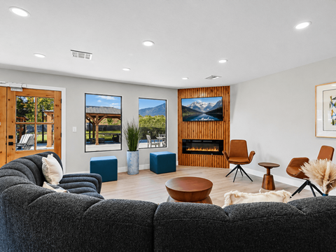 A living room with a grey couch and a wooden fireplace.