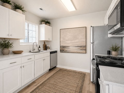 A kitchen with white cabinets and a black stove top oven.