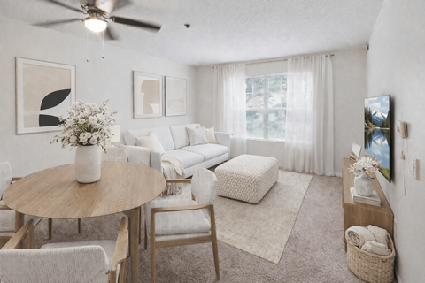 A living room with a round table and chairs, a sofa, and a television.