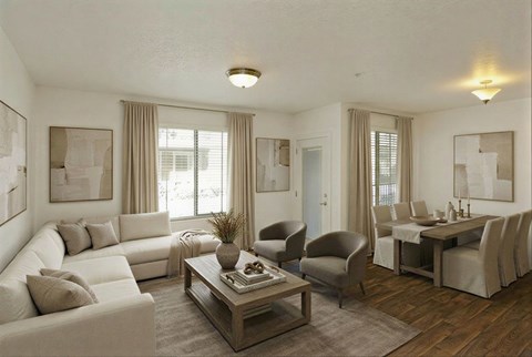 A living room with a white couch, a coffee table, and a dining table set up.