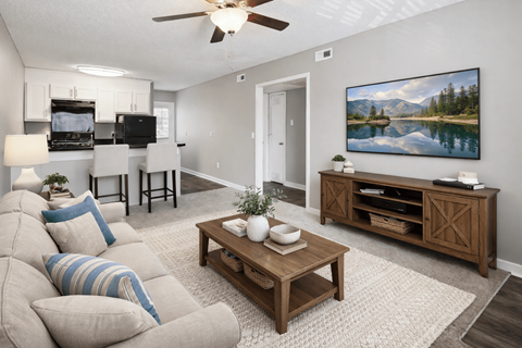 A living room with a couch, a coffee table, and a painting on the wall.