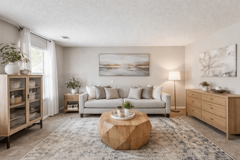 A living room with a couch, a coffee table, and a painting on the wall.