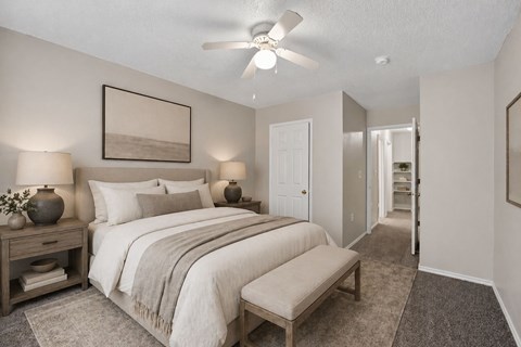 A bedroom with a large bed and a ceiling fan.