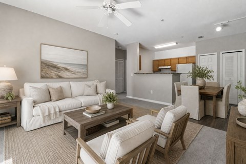 A living room with a white couch, a wooden coffee table, and a painting of a beach scene on the wall.