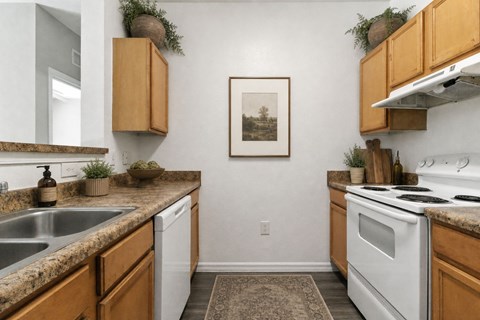 A kitchen with wooden cabinets and a white oven.