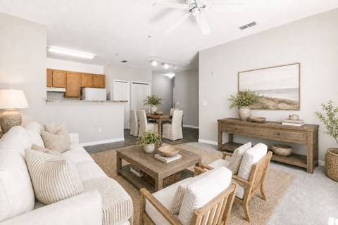 A living room with a white couch, wooden chairs, and a rug.
