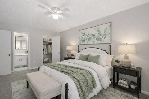 A bedroom with a large bed and a ceiling fan.