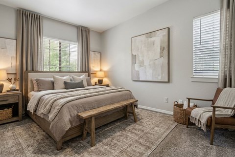 A bedroom with a large bed and a bench.